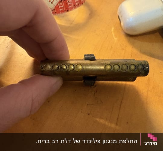 צילינדר מנעול על שולחן עץ עם ידיים